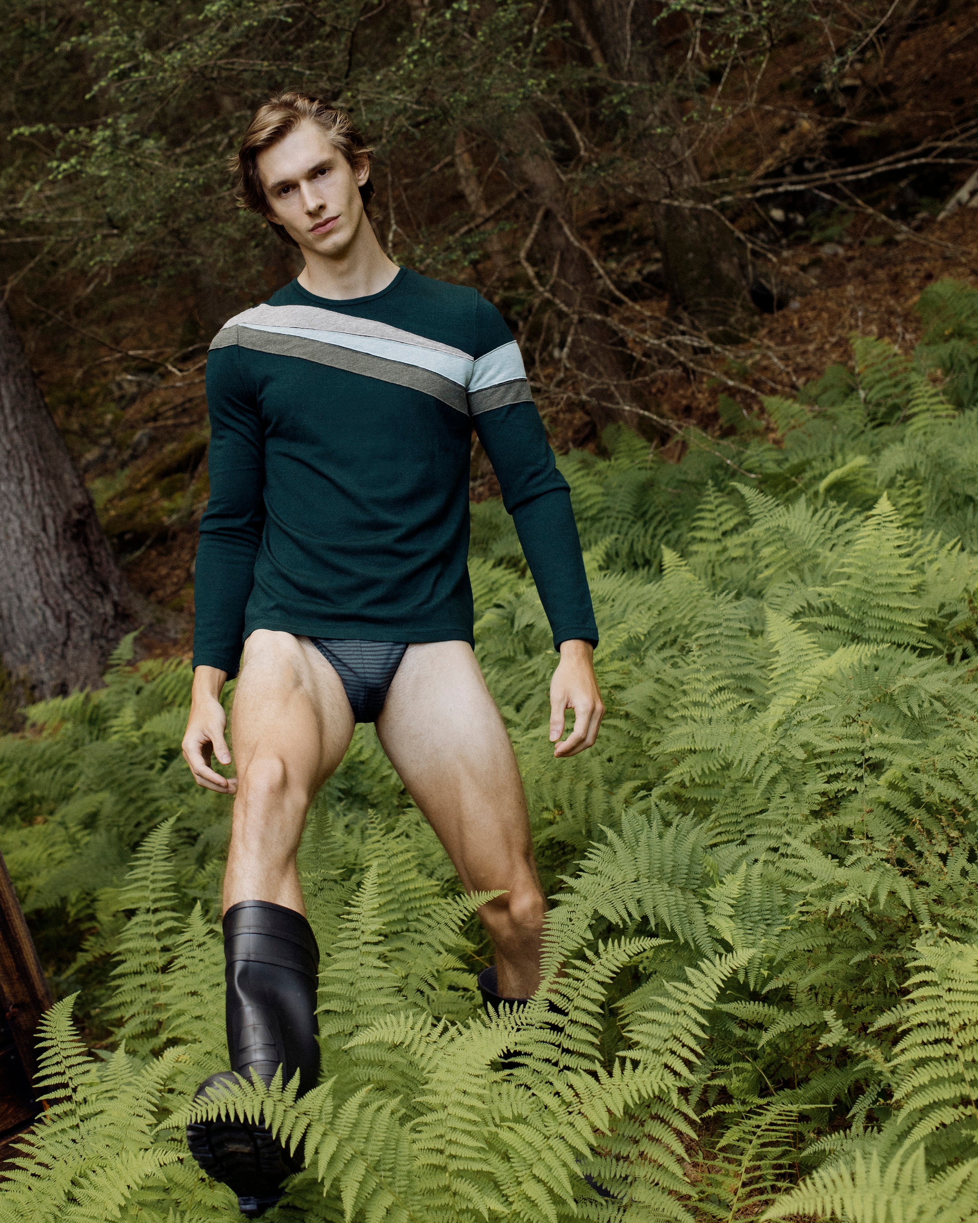 Parke & Ronen Fall 2025 collection. Male model wears Green colorblocked stripe knit jersey and green stripe sports brief underwear.