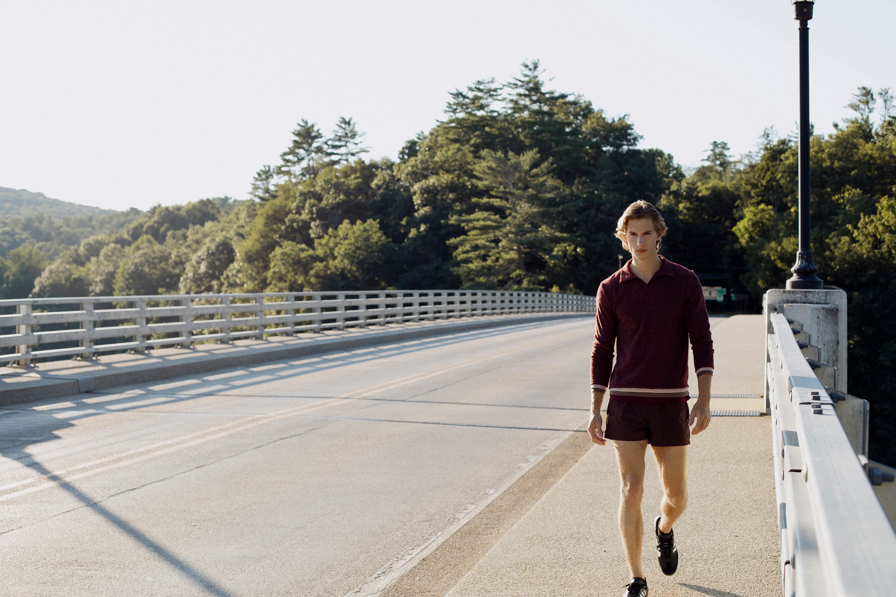 Parke & Ronen Fall 2025 collection. Male model wears burgundy Rowe Polo and Maroon activewear shorts.