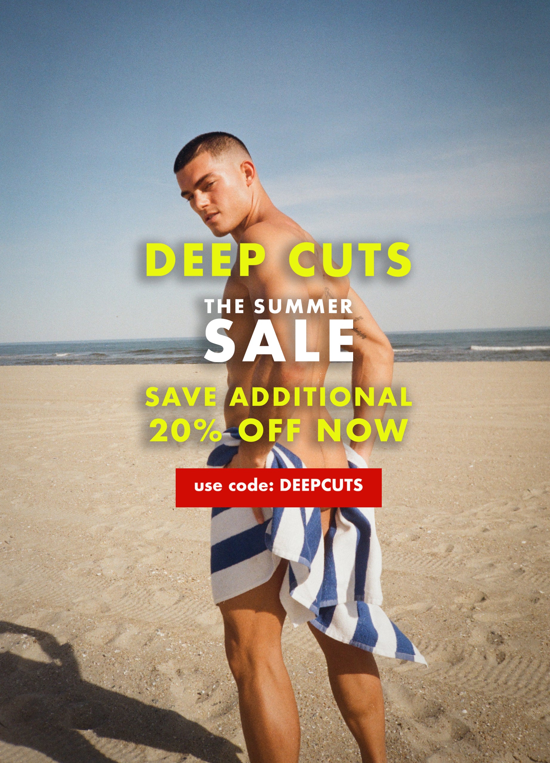 Image of a Man wrapped in towel on the beach. with text: The Summer Sale- Deep Cuts! Save an additonal 20% off now. use code: DEEPCUTS