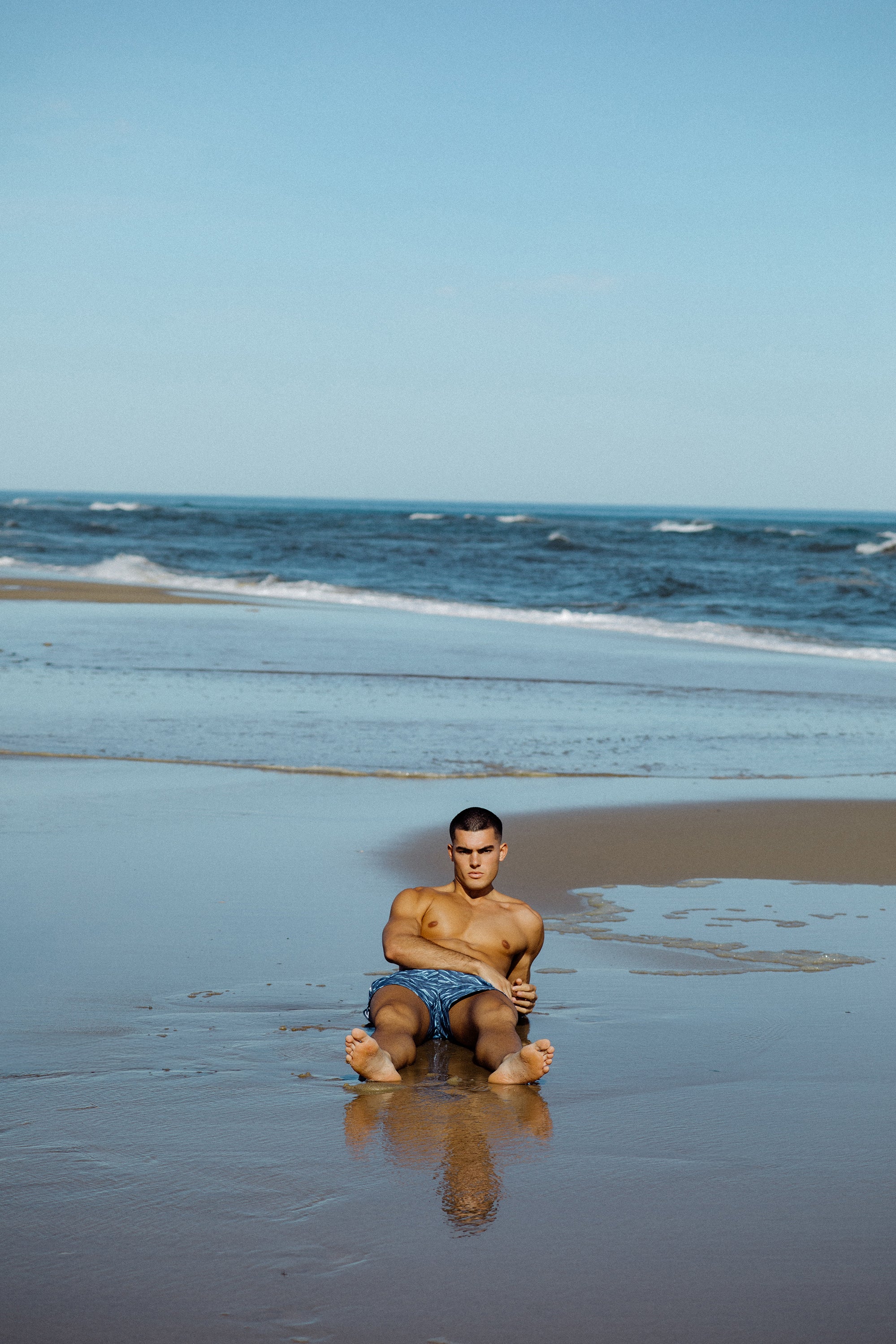 Parke & Ronen Summer 2025. Male model wearing Blue Waves printed Angeleno Swim trunk.
