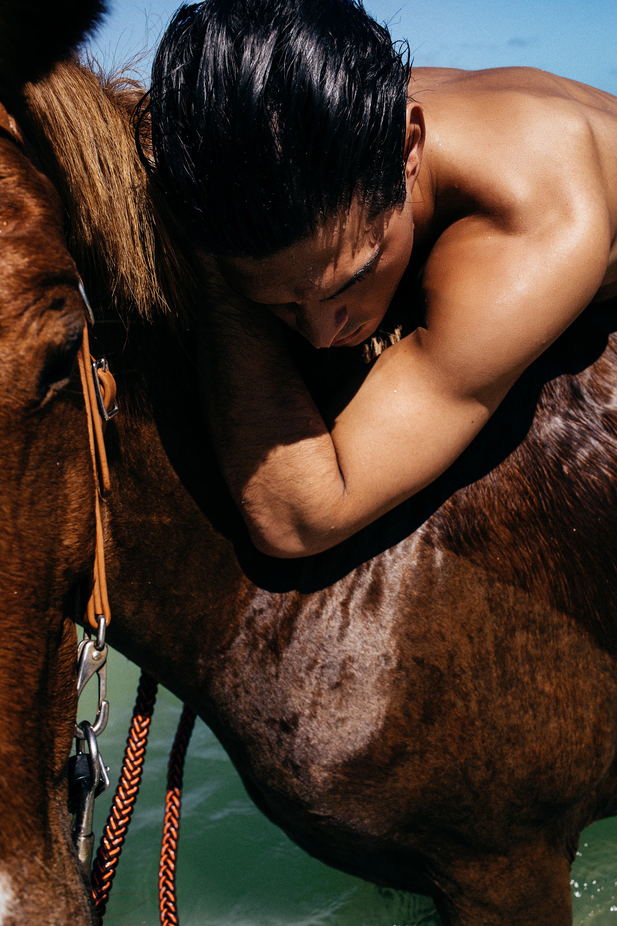 Parke & Ronen Summer 2025. Male model with sun tan pictured riding a horse.